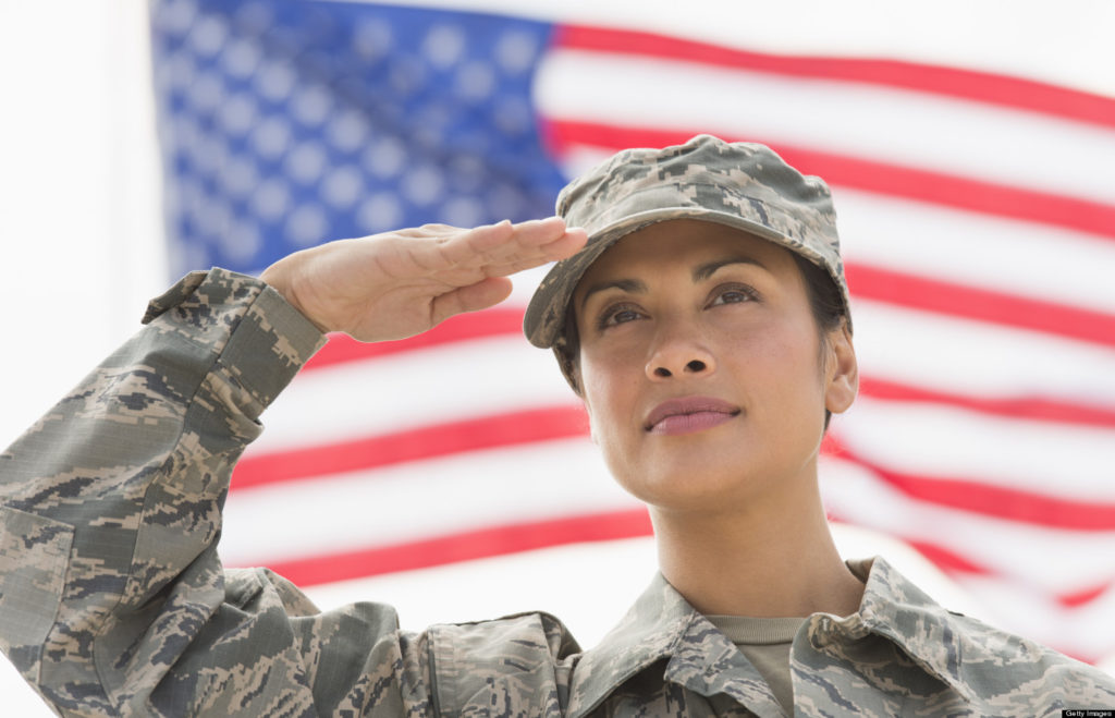 USA, New Jersey, Jersey City, Female army soldier saluting, American flag i...