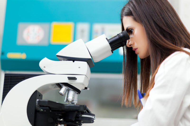 woman scientist looking through microsope