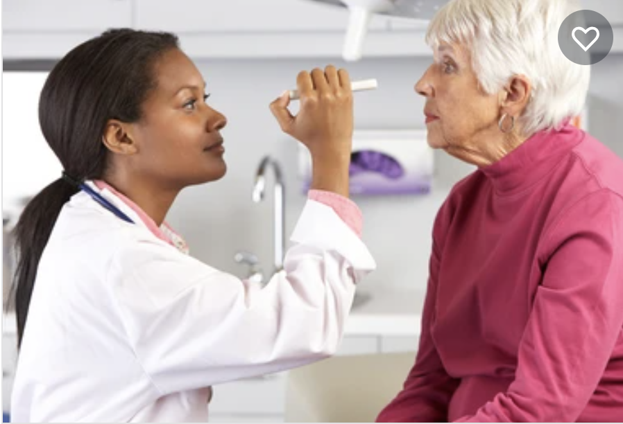 doctor examining older woman's eyes