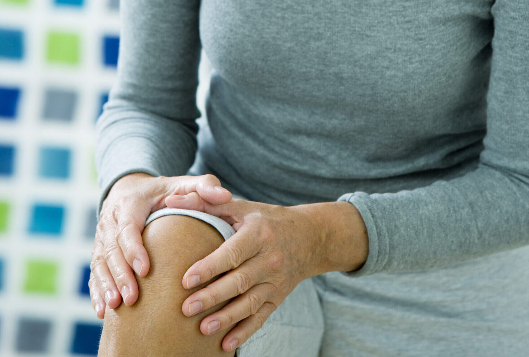woman holding her hurt knee